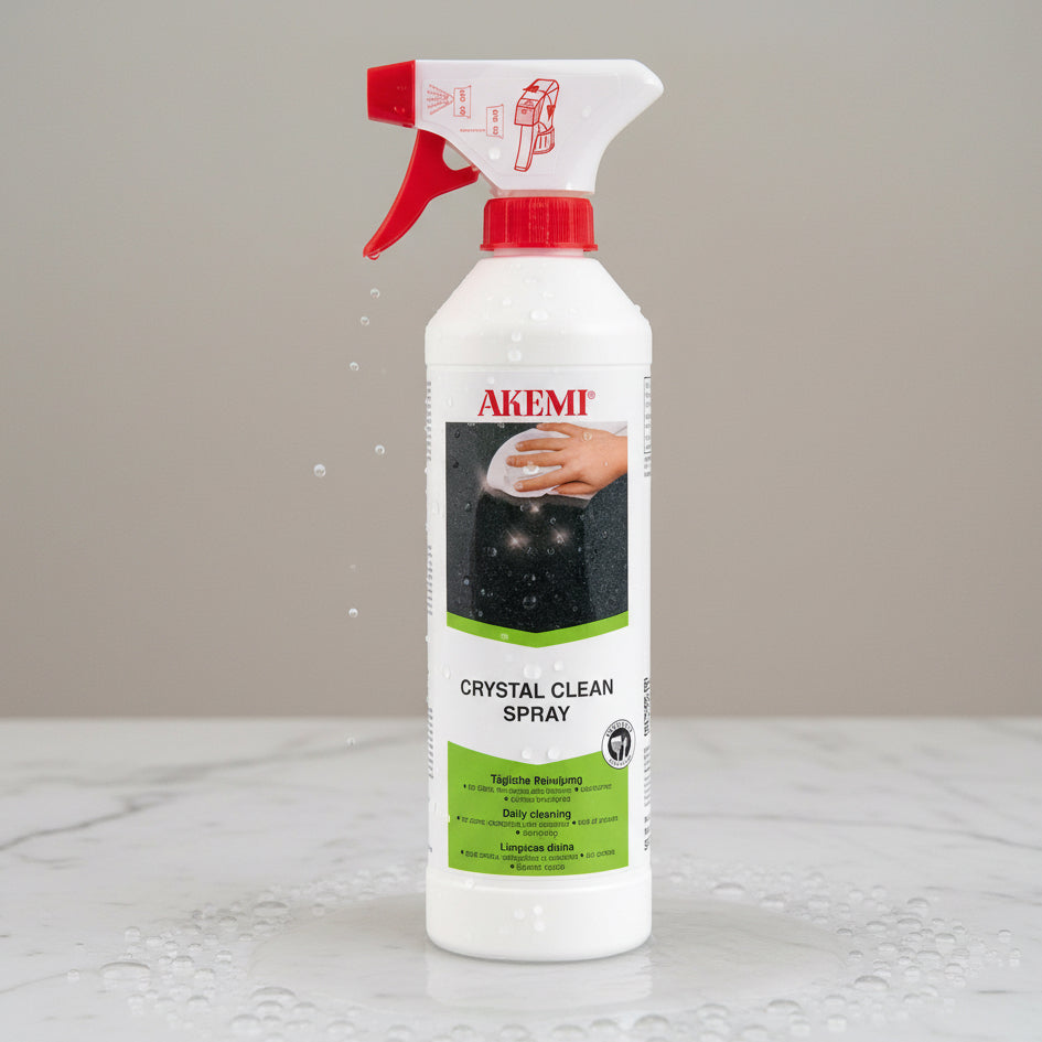 A white spray bottle with a red nozzle labeled 'AKEMI Crystal Clean Spray' designed for cleaning stone surfaces.
