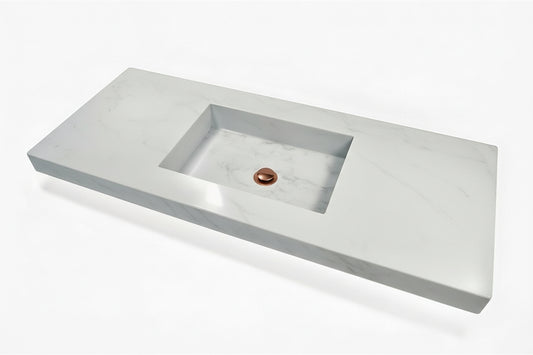 Rectangular Stone sink with a copper drain on a white background